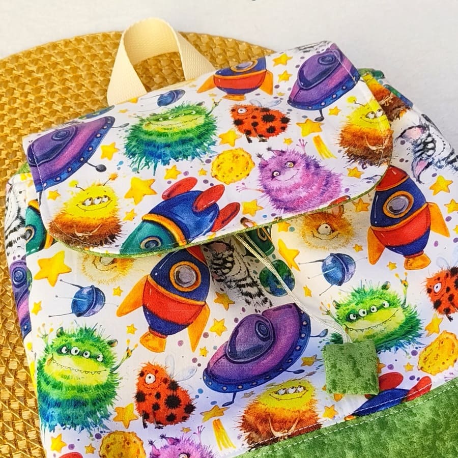 Mochila Solapa Mini Infantil - Naves Espaciales Extraterrestres · <p class="MsoNormal" style="margin-bottom: 0cm;text-align: justify;line-height: 150%">Mochila infantil Naves Espaciales Extraterrestres personalizada, hecha a mano en telas de algodón, ligera, cómoda y única con nombre bordado.</p> · Tienda de simple para ArteLovers Mochila Solapa Mini Infantil - Naves Espaciales Extraterrestres - Imagen 2