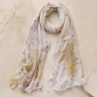 ArteLovers regalos hechos a mano por mujeres artesanas · · Tienda de para ArteLovers Market Fular ligero de color claro con estampación botánica en tonos rosa, amarillo, beige y violeta, colocado sobre fondo neutro