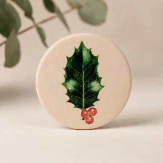 Imán botánico circular de cerámica blanca con ilustración de hoja de acebo y bayas rojas