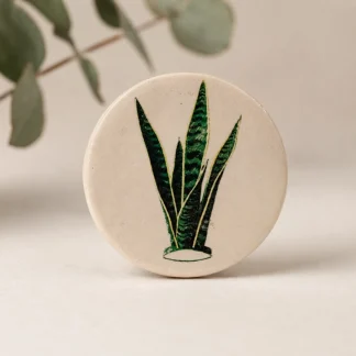 Imán botánico circular de cerámica blanca con ilustración de sansevieria trifasciata