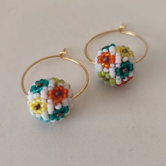Aros dorados con cuentas de flores base blanca