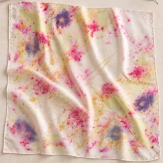 ArteLovers regalos hechos a mano por mujeres artesanas · · Tienda de para ArteLovers Market Pañuelo cuadrado extendido sobre una superficie beige, con huellas vegetales y manchas rosas, violetas, amarillas y verdes.